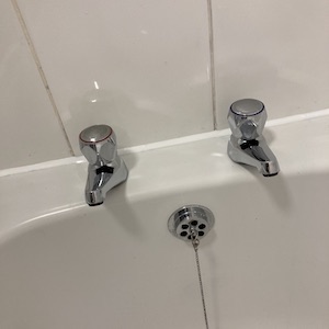 Descaled bath taps with fresh clean silicone behind  after a Bathroom Revival, silicone replacement & deep cleaning service.
