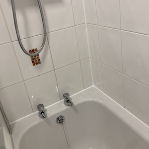 Descaled bath taps with fresh clean silicone, tiles & grout after a Bathroom Revival, silicone replacement & deep cleaning service.
