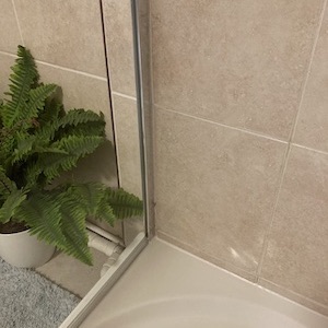 Bathroom Revival before & after photo of crystal clear shower glass, mould & stain free tiles & grout and new antifungal silicone sealant. 

